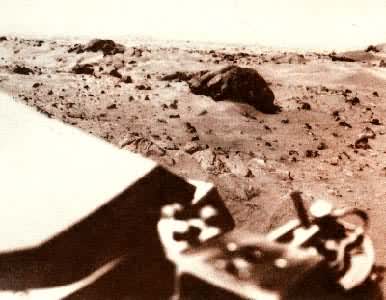 火星表面照片  火星上空中有一层薄雾，前面的大石块有三米宽1米高，周围砂石混杂。
