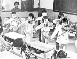 辽宁省兴城县小学音乐教师在辅导学生拉小提琴